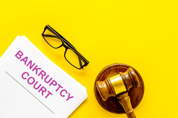 Title of documents the bankruptcy court near judge gavel on yellow background top view copy space