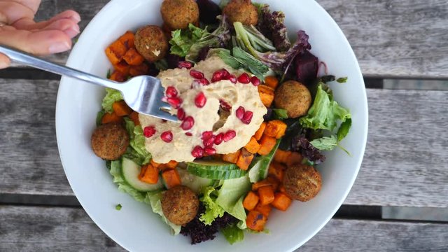 Fresh Vegetable Salad With Hummus And Falafel On Wooden Background