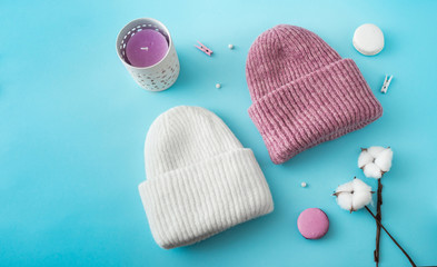Knitted hats, cotton sprigs, macaroons close-up on a white