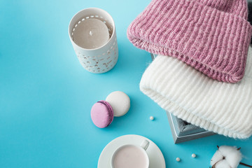 Knitted hats, cotton sprigs, macaroons close-up on a white