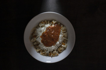 plates of turkish traditional food . mantı with sauce on it