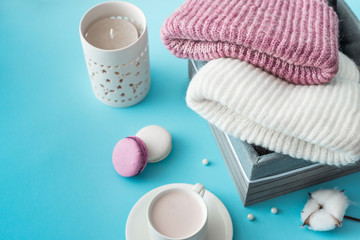 Fototapeta na wymiar Knitted hats, cotton sprigs, macaroons close-up on a white