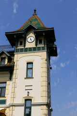 Fototapeta na wymiar Fragment of a building with a tower with a round clock