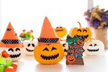 White and yellow ghost pumpkins with witch hat and Happy halloween text on borad. halloween concept.