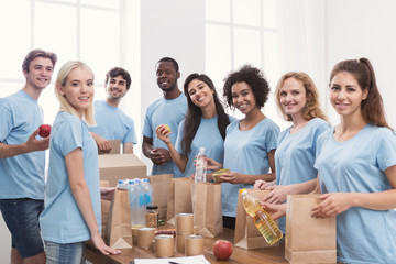 Volunteers putting food and drinks into paper bags