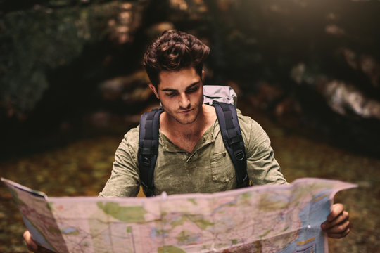 Male hiker using a map to locate the destination