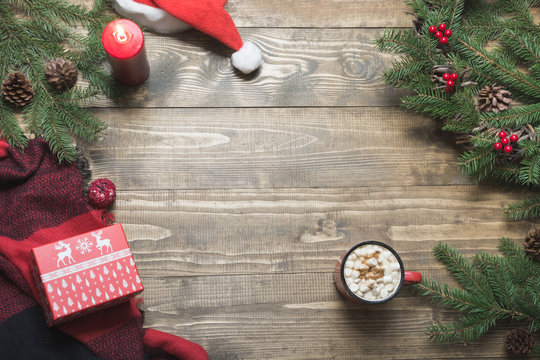 Christmas composition of wreath,checkered pleid, cup of coffee on wooden board. Top view. Copy space.