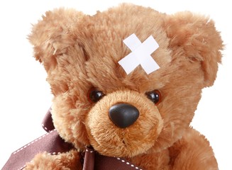 Teddy Bear with Crossed Adhesive Bandages on Head - Isolated