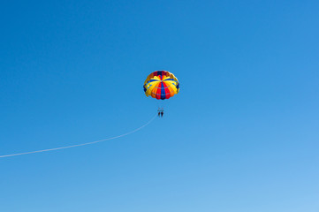 Happy couple Parasailing in Dominicana beach in summer. Couple under parachute hanging mid air. Having fun. Tropical Paradise. Positive human emotions, feelings, family, children, travel, vacation.