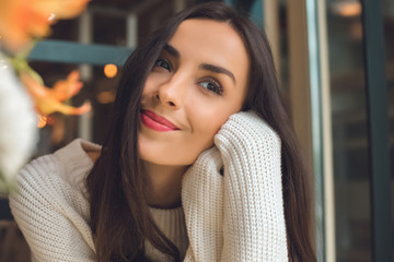 dreamy young beautiful woman looking away in cafe