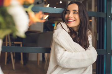 selective focus of attractive young woman with closed eyes in cafe