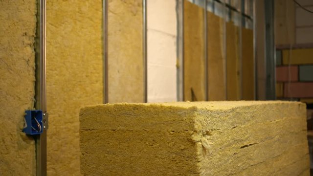 A contractor grabs a sheet of insulation for basement remodel - manly concept