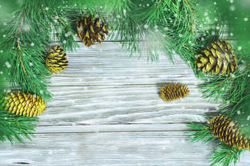 Christmas card. Branches of Christmas tree, Golden cones, falling snow. Top view and copy space.