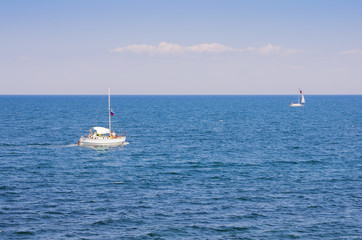Pleasure yacht in the open sea. Russia, the Crimea peninsula, the Black Sea. Seascape with two pleasure yachts