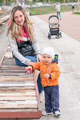 Happy mother and little baby boy playing in the park. Autumn.