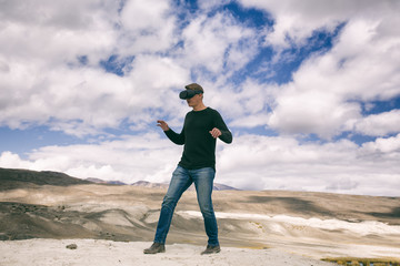  man in virtual reality glasses goes against the background of nature. Man in the game