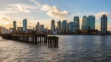 Fototapeta na wymiar Modern skyscrapers of Canary Wharf with old overgrown pier and Thames in foreground, January 2018, Greenwich London