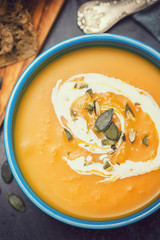 Homemade pumpkin soup served with cream and pumpkin seeds