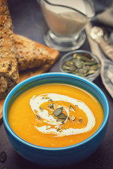 Homemade pumpkin soup served with cream and pumpkin seeds