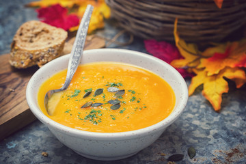 Homemade pumpkin soup served with parsley and pumpkin seeds