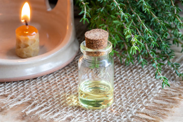 A bottle of thyme essential oil with fresh thyme twigs