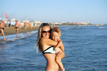 Fototapeta premium Mother and son playing on the beach in the day time