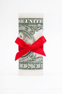 one dollar bill wrapped with a red bow on white background