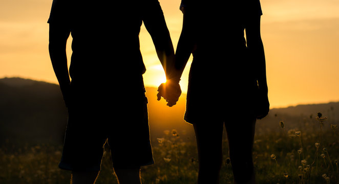 Silhouette of a couple holding hands