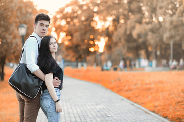 Young couple on a walk in autumn park 