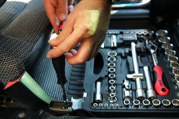 Hands of a man repairing his car