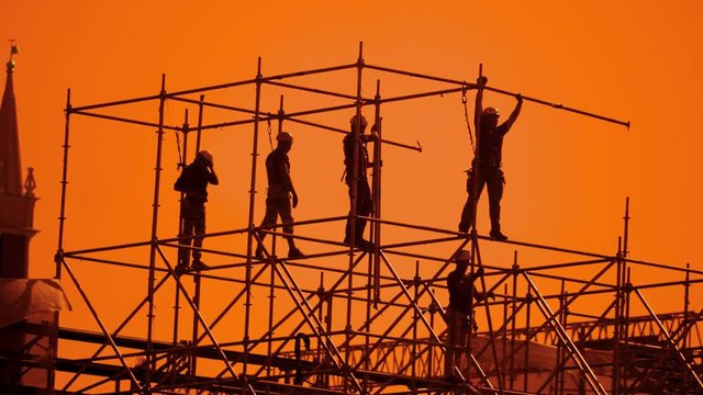 workers silhouette at sunset builders collect the design. construction workers concept building lifestyle silhouette men slow motion video group