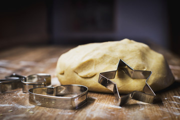 Christmas baking. Making gingerbread biscuits. Cookie dough and cookie cutters on kitchen counter.