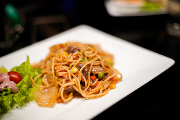 Spaghetti dish with beef and bean on the white disk