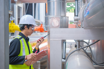 Asian Maintenance engineer at the waste water management system of a huge factory,maintenance checking technical data of heating system equipment,Thailand people