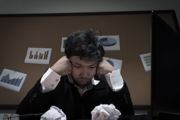 Asian businessman under stress due to excessive work,Feeling exhausted,Young clerk has a problem in a office,sad man from work,Angry messy man concept