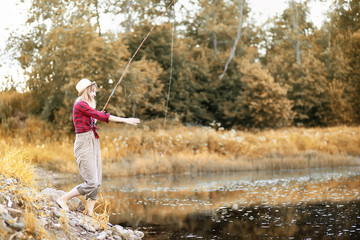 Girl in autumn with a fishing rod