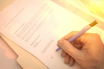 Financial contract for business purchase agreement.  Paper documents with pen and hand signing.