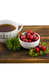 Cranberry tea in a cup on a wooden background. Cranberry tea and berries on a wooden surface.