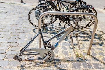 Obraz premium Bicycle frame without wheels, with locker lay on the street parking, stolen bicycle concept