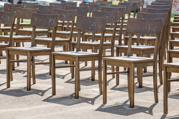 Fototapeta na wymiar Commemoration memorial to the holocaust of Jews: art installation of empty chairs at city street