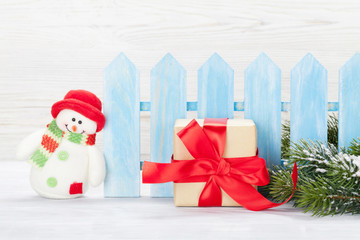 Christmas gift box, snowman toy and fir tree branch