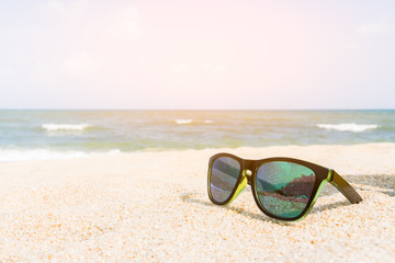 Fototapeta na wymiar Sunglasses on the sandy coast