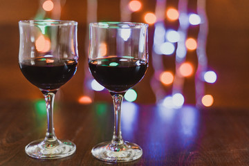 two glasses of red wine on the background of lights
