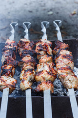 Barbecue on the grill. Shashlik made of cubes of meat on the skewers during of cooking on the mangal over charcoal