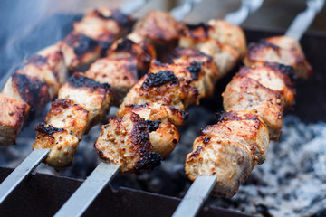 Barbecue on the grill. Shashlik made of cubes of meat on the skewers during of cooking on the mangal over charcoal