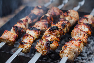 Barbecue on the grill. Shashlik made of cubes of meat on the skewers during of cooking on the mangal over charcoal