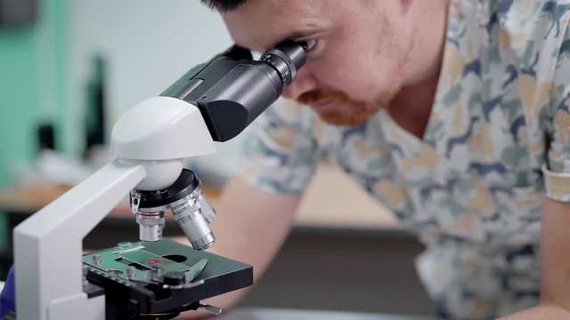 Doctor doing blood test with microscope