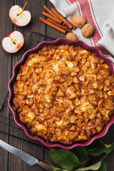 Apple and cinnamon homemade pie with walnuts and custard on an old concrete background. Rustic style. Top view.