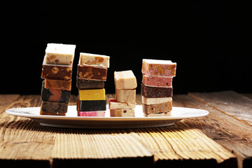Delicious traditional Italian festive torrone or nougat with nuts on wooden background. Soft nougat...