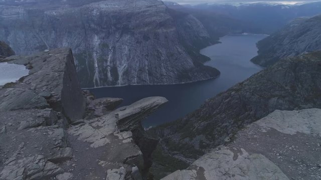 Trolltunga Mountain Cliff in Norway. Famous Troll Tongue Rock in Summer Day. Aerial View. Drone is Flying Forward, Camera is Tilting Down
